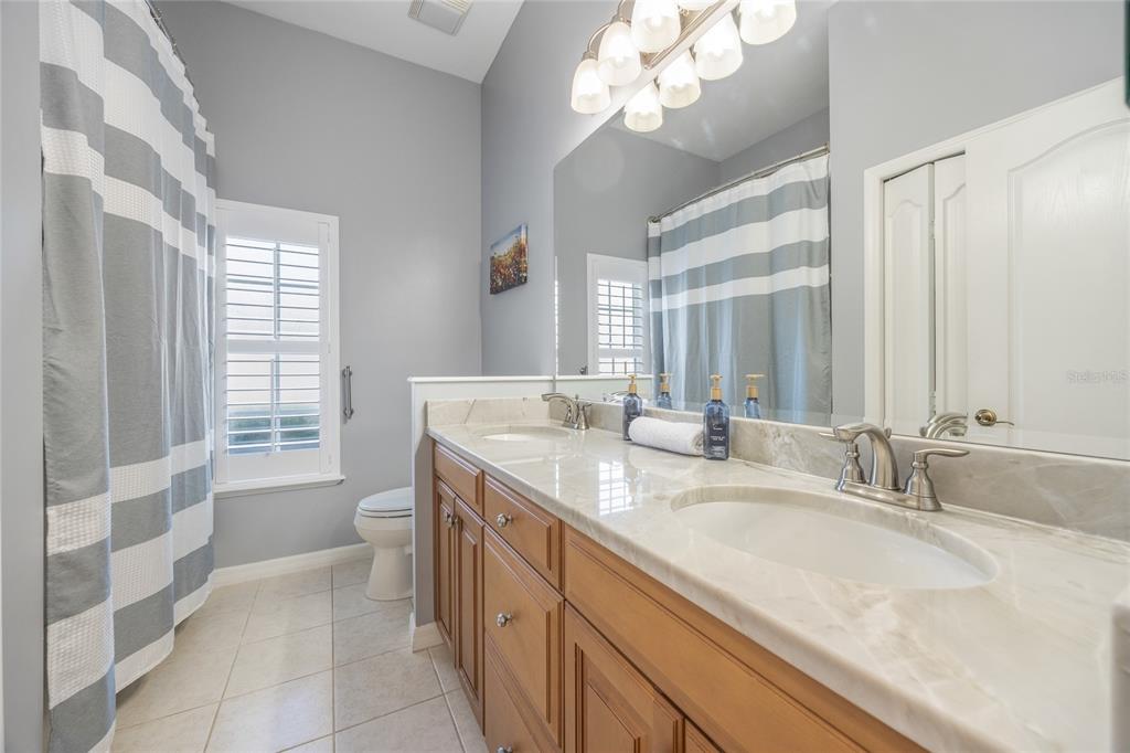 7146 Southwest 35th Avenue Gainesville, FL 32608 - Photo 53 of 83 a bathroom with a granite countertop sink a large mirror and a bathtub