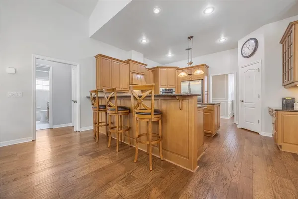 a kitchen with stainless steel appliances granite countertop a refrigerator a sink and a stove
