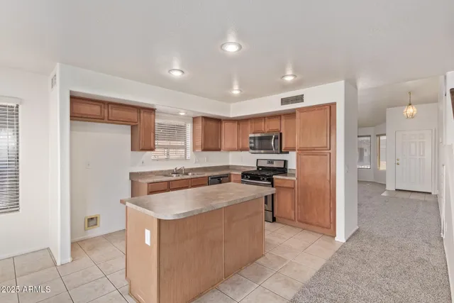 a kitchen with stainless steel appliances granite countertop a stove a refrigerator and a sink