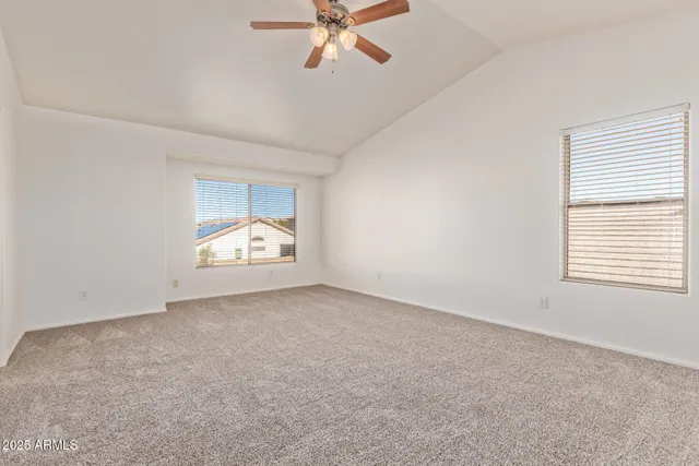 an empty room with a window and a ceiling fan