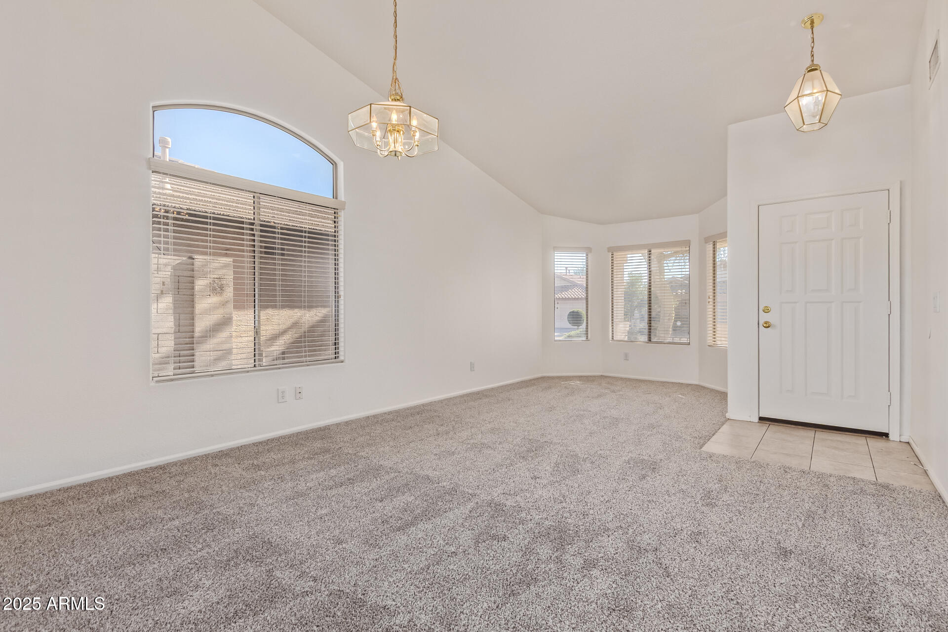 2432 West Blue Sky Drive Phoenix, AZ 85085 - Photo 8 of 40 en empty room with windows and chandelier