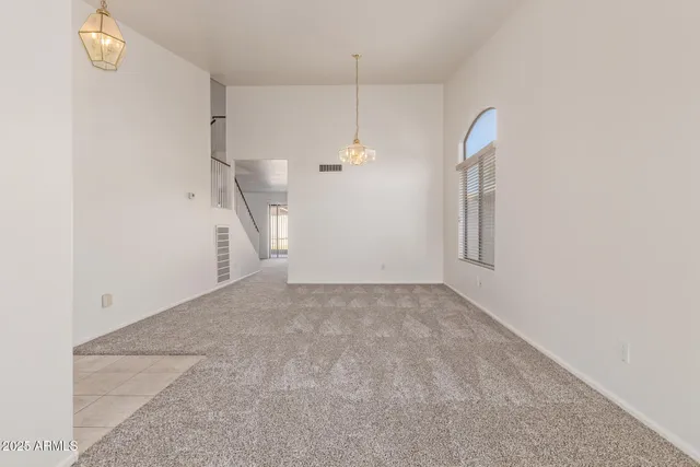 a view of a room with stairs and a chandelier fan