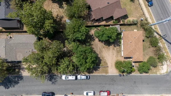 an aerial view of a house with garden space and street view