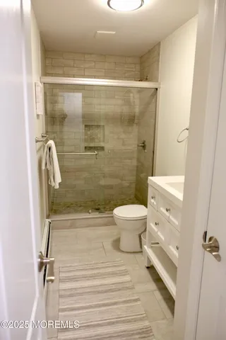a bathroom with a shower a toilet and a sink