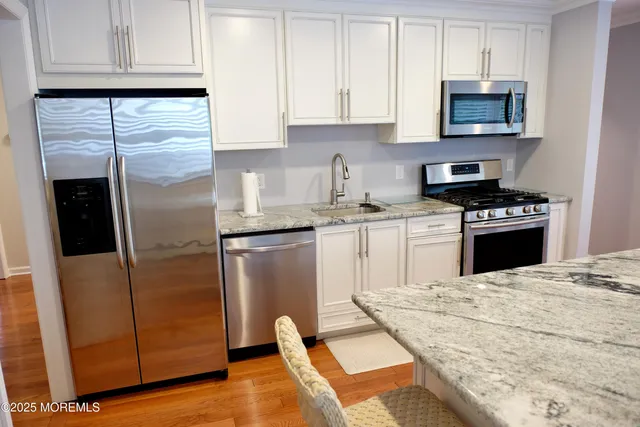 a kitchen with granite countertop wooden cabinets and a stove top oven
