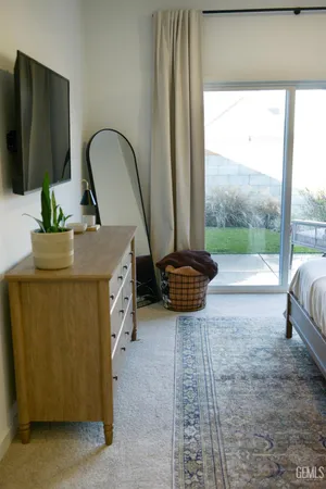 a living room with couches a flat screen tv and a large window