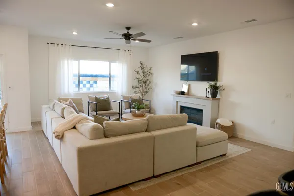 a living room with furniture a flat screen tv and a window