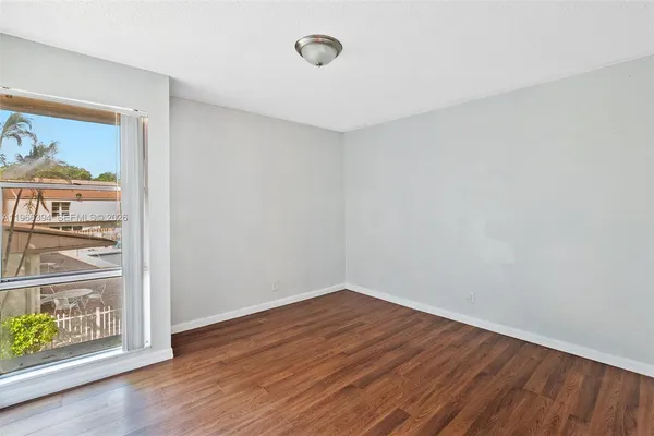 a view of a room with wooden floor and window