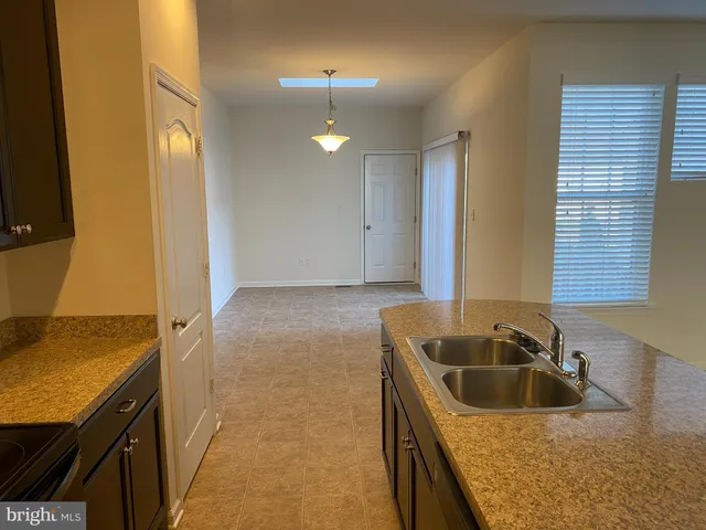 a kitchen with granite countertop a sink a stove and cabinets