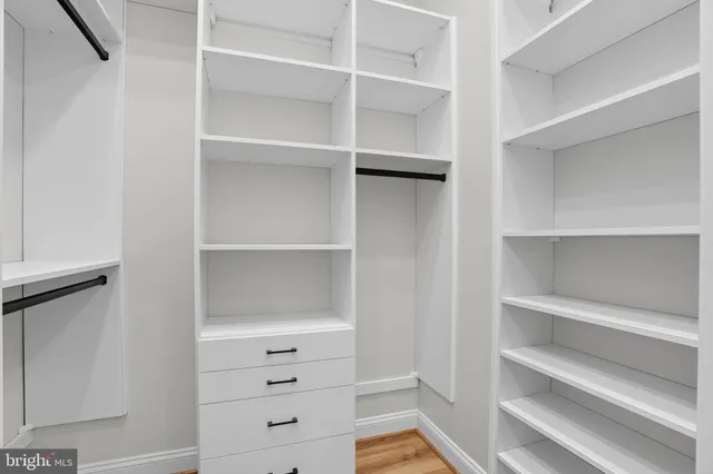 a view of walk in closet with empty racks