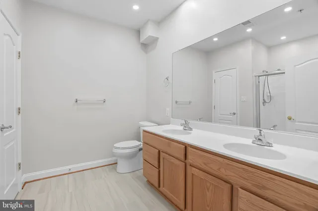 a bathroom with a double vanity sink toilet and a mirror