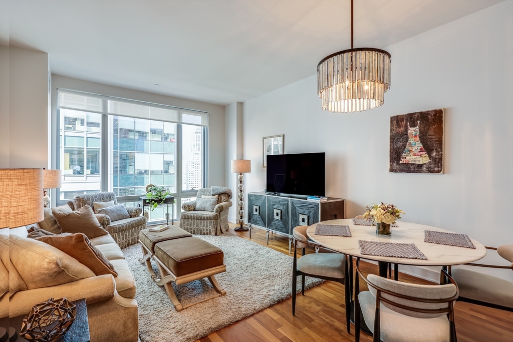 500 Atlantic Avenue, Unit PH20L Boston, MA 02210 - Photo 1 of 12 a living room with furniture a chandelier and a flat screen tv