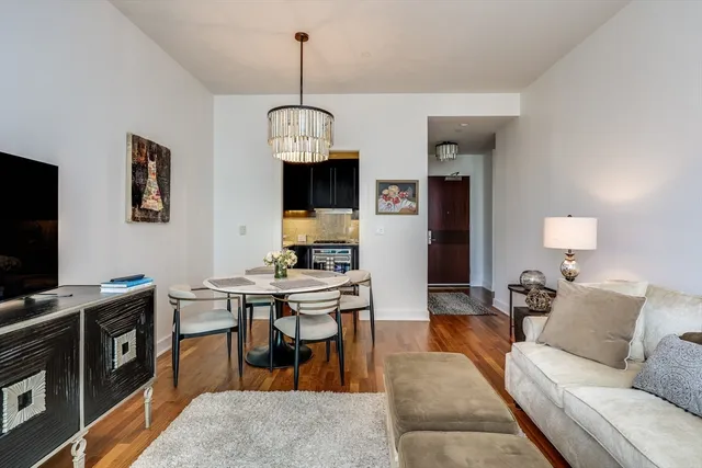 a living room with furniture a chandelier and a flat screen tv