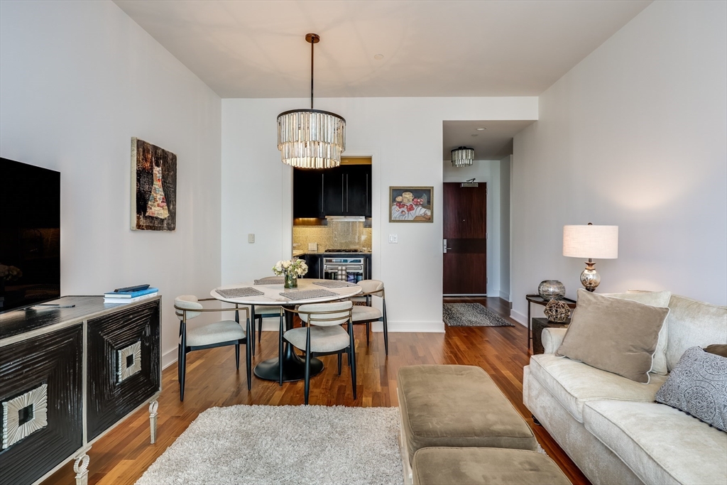 500 Atlantic Avenue, Unit PH20L Boston, MA 02210 - Photo 3 of 12 a living room with furniture a chandelier and a flat screen tv