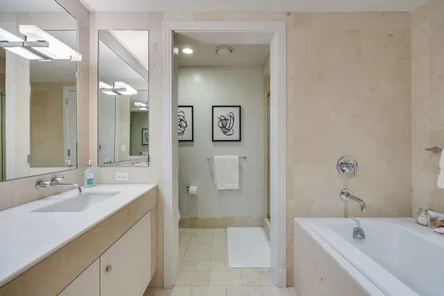 a bathroom with a tub sink and mirror