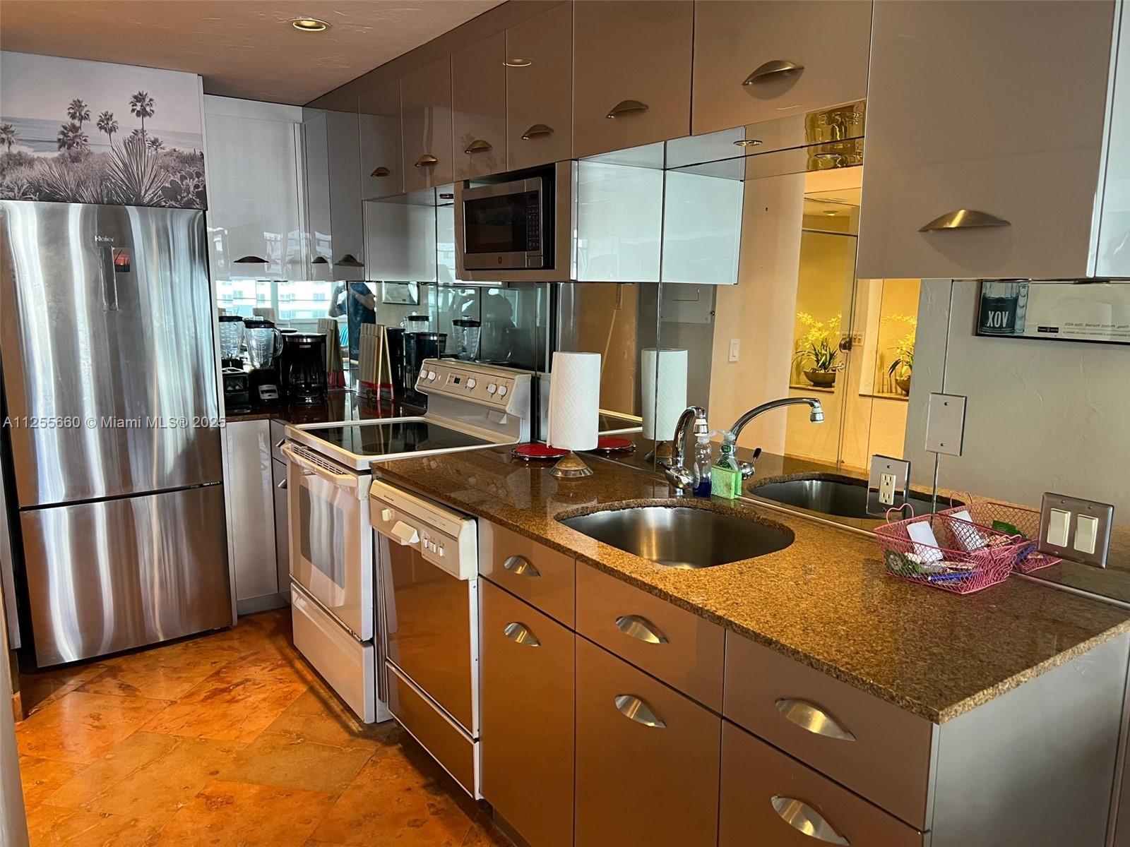 100 Lincoln Road, Unit 1228 Miami Beach, FL 33139 - Photo 16 of 70 a kitchen with refrigerator a sink and cabinets