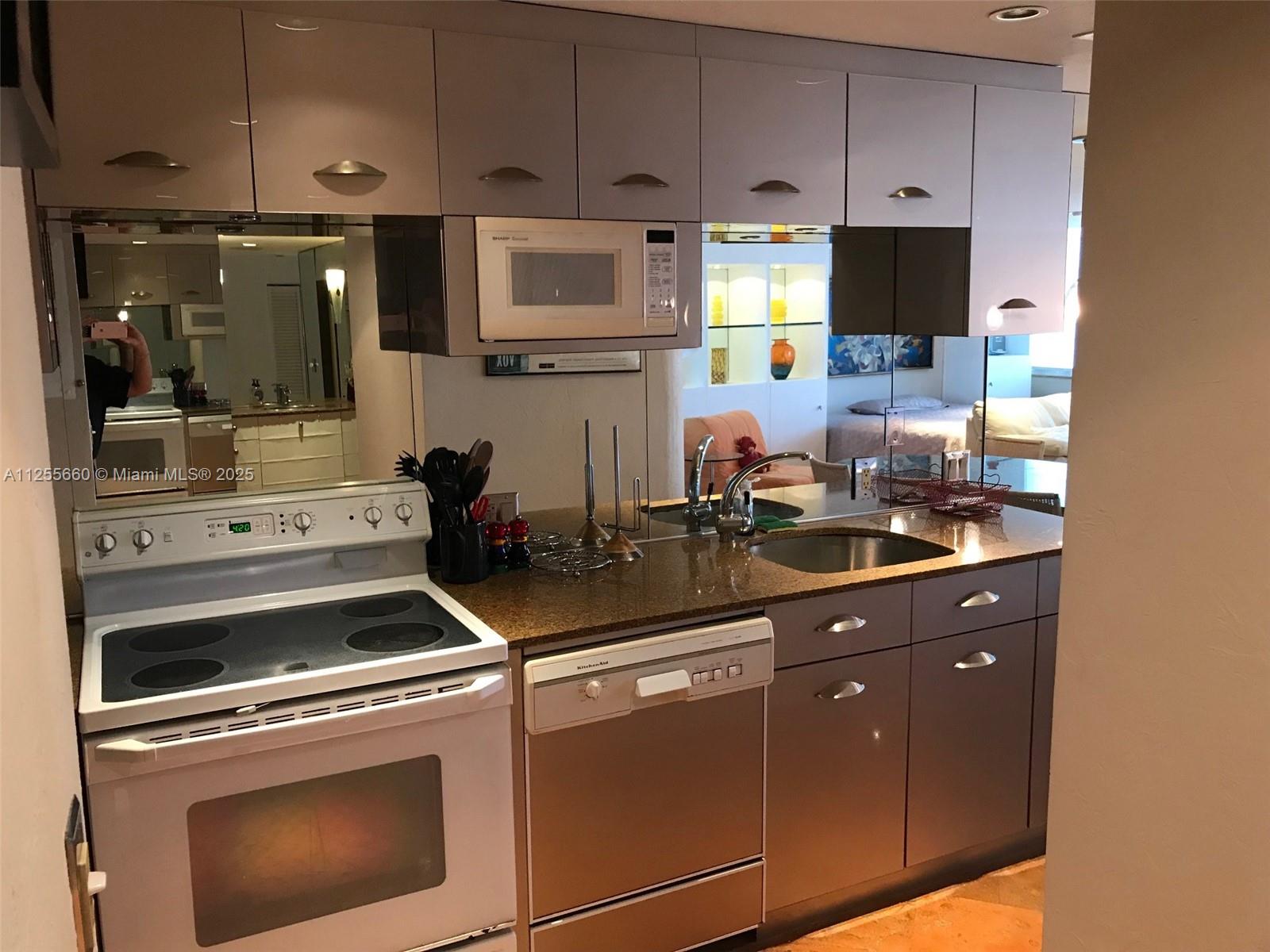 100 Lincoln Road, Unit 1228 Miami Beach, FL 33139 - Photo 18 of 70 a kitchen with appliances a sink and cabinets