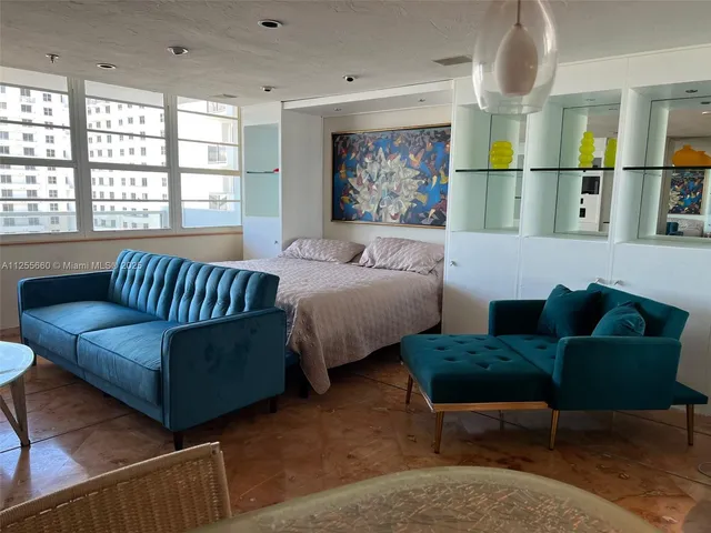 a living room with furniture a rug and wall paintings