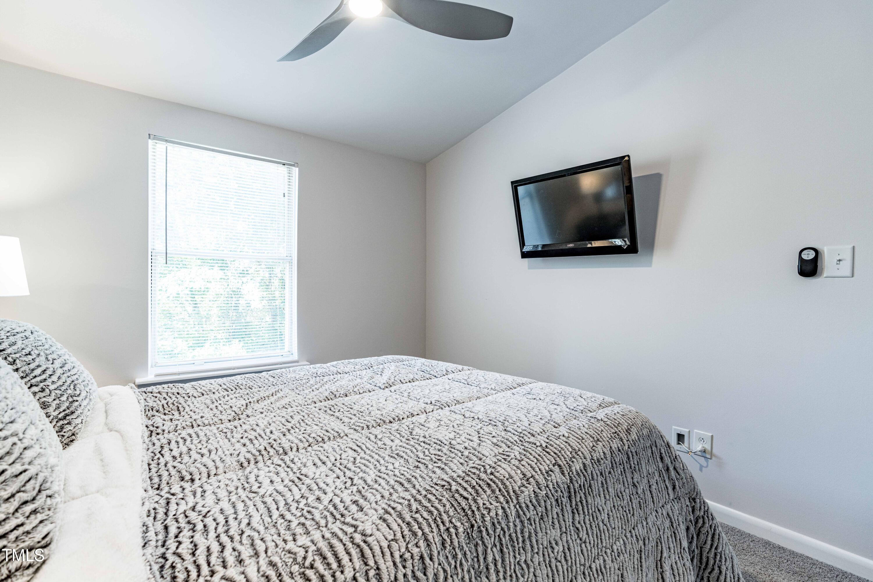 1708 Ithaca Lane, Unit A Raleigh, NC 27606 - Photo 21 of 30 a bedroom with a bed and a flat screen tv