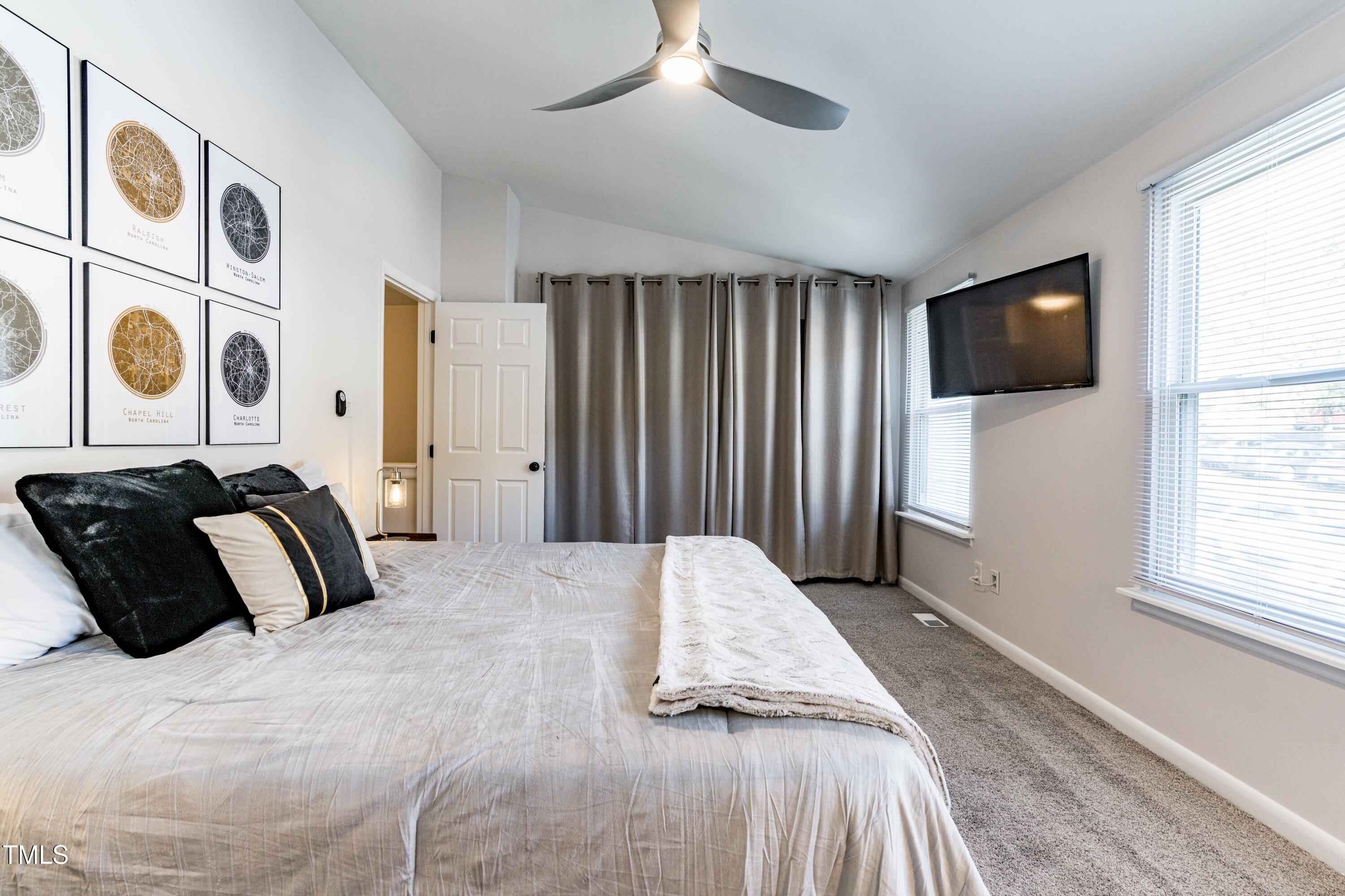 1708 Ithaca Lane, Unit A Raleigh, NC 27606 - Photo 24 of 30 a bedroom with a bed and a flat screen tv