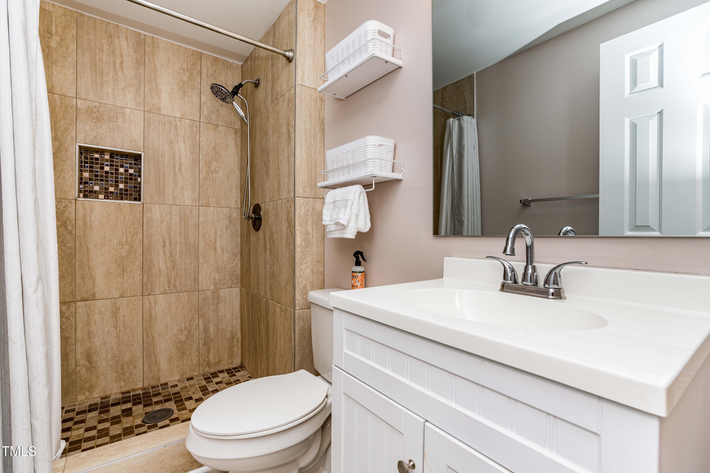 1708 Ithaca Lane, Unit A Raleigh, NC 27606 - Photo 27 of 30 a bathroom with a sink a toilet and shower