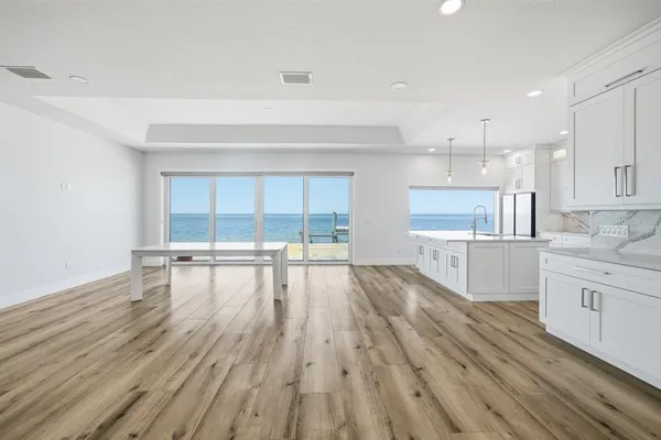 a view of large kitchen with wooden floor and windows