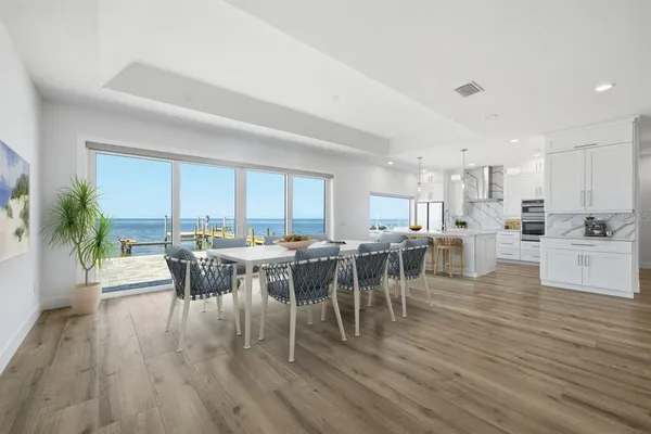 a view of a dining room and livingroom with lots of furniture and view of kitchen