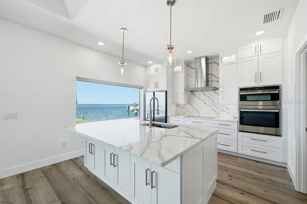 a kitchen with stainless steel appliances kitchen island a large island in the center