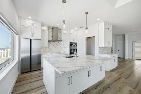 a kitchen with stainless steel appliances granite countertop a refrigerator a sink and a stove