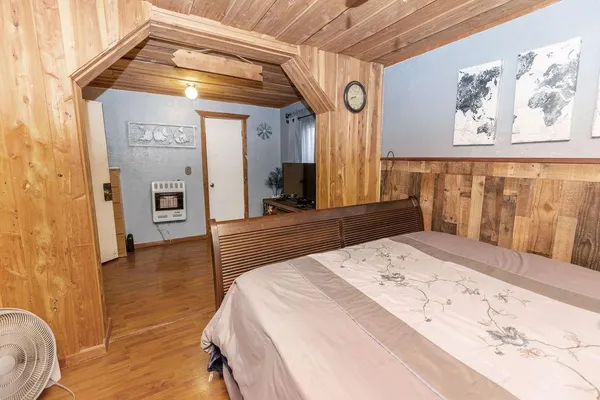 a spacious bedroom with a bed and a dresser
