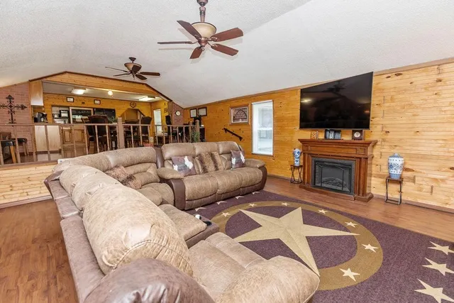a living room with furniture a flat screen tv and a fireplace