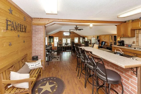 a dining hall with stainless steel appliances a dining table and chairs with wooden floor
