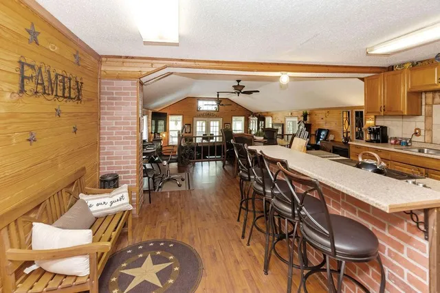 a dining hall with stainless steel appliances a dining table and chairs with wooden floor