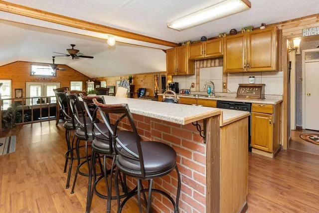 a kitchen with stainless steel appliances a table chairs refrigerator and sink