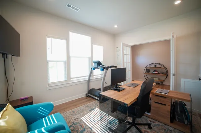 a living room with furniture a flat screen tv and a window