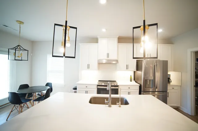 a kitchen with stainless steel appliances a stove a refrigerator and wooden floor