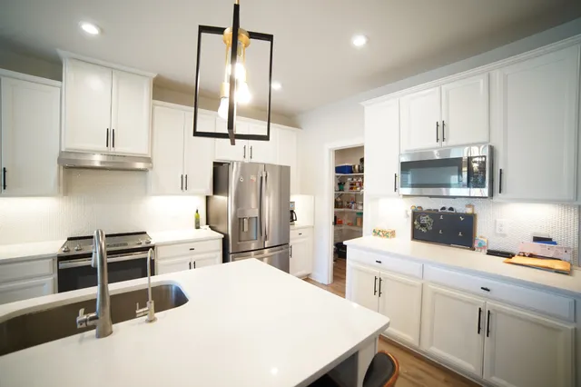 a kitchen with stainless steel appliances a refrigerator stove microwave and sink