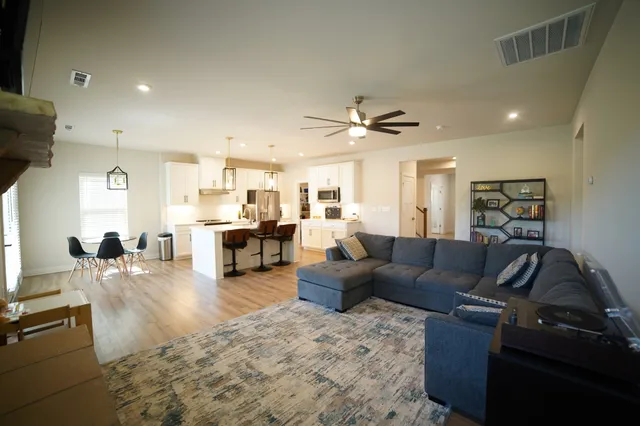 a living room with furniture and view of kitchen