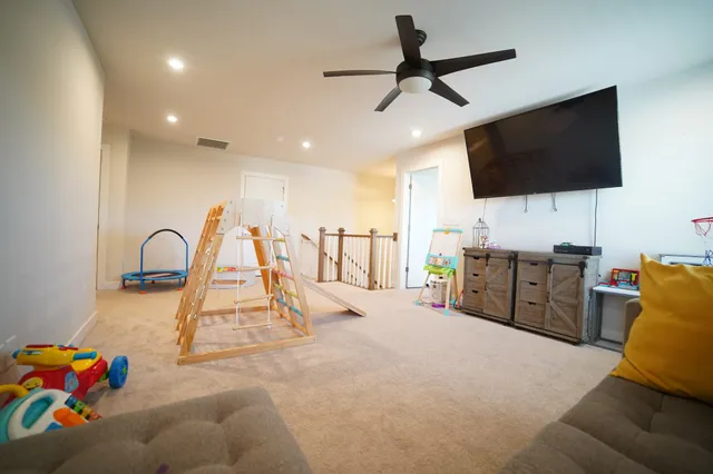 a view of a room with gym equipment and a flat screen tv