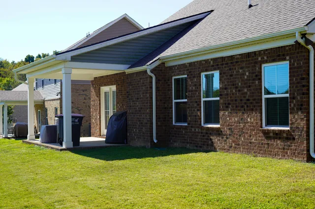 a view of a house with yard and porch