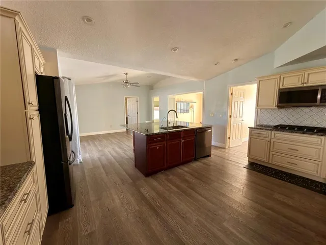 a large kitchen with kitchen island white cabinets and stainless steel appliances
