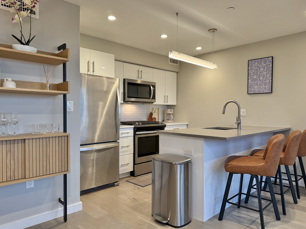 a kitchen with stainless steel appliances a refrigerator and a stove top oven