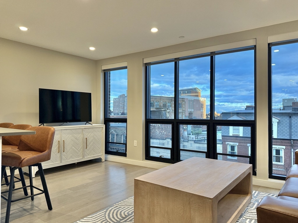 244 Hanover Street, Unit 610 Boston, MA 02113 - Photo 3 of 15 a living room with furniture and a flat screen tv