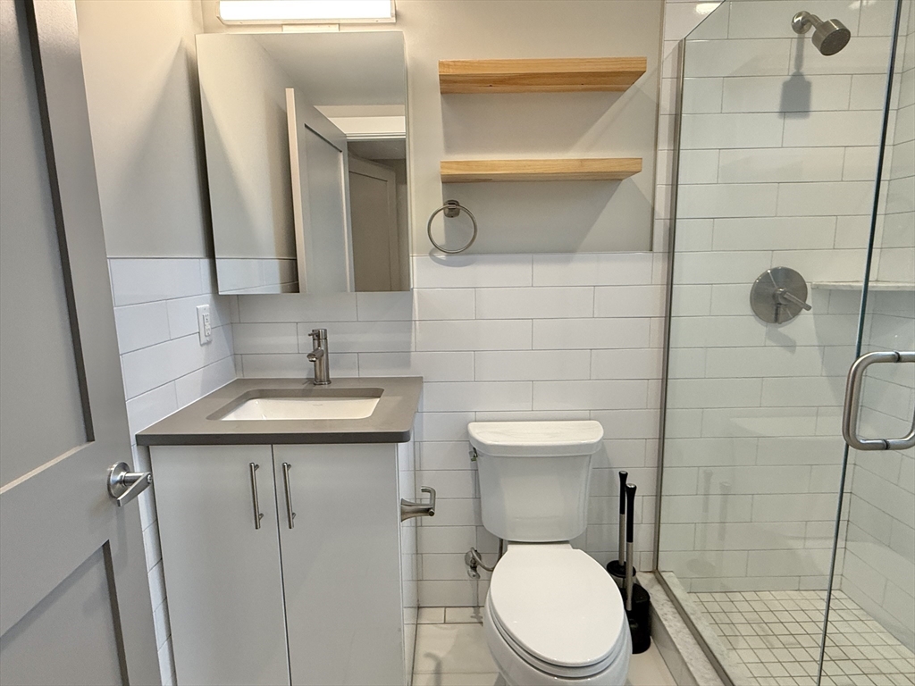 244 Hanover Street, Unit 610 Boston, MA 02113 - Photo 6 of 15 a bathroom with a sink a toilet and shower
