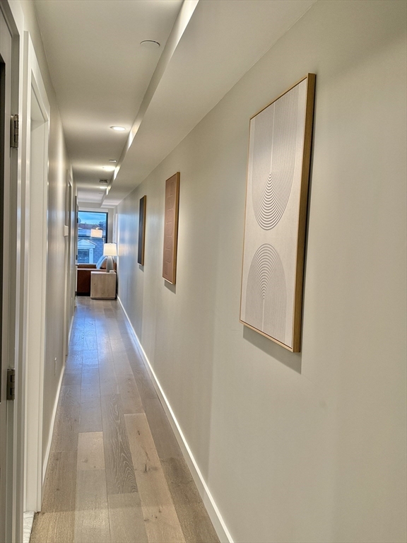 244 Hanover Street, Unit 610 Boston, MA 02113 - Photo 8 of 15 a view of a hallway with wooden floor and a living room