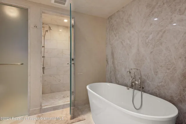 a white bath tub sitting next to a shower