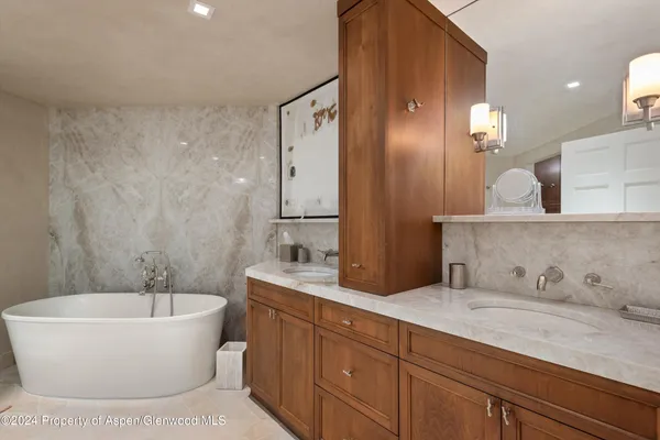 a spacious bathroom with a bathtub sink and mirror