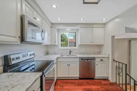 a kitchen with stainless steel appliances granite countertop a sink stove and refrigerator