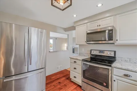 a kitchen with stainless steel appliances a stove microwave and sink