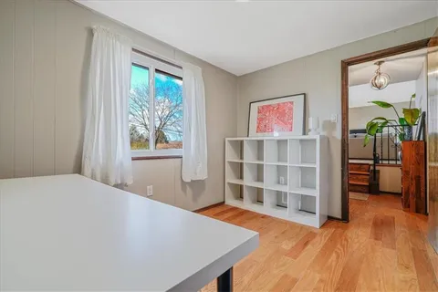 a view of a bedroom with wooden floor and windows
